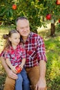 grandfather with granddaughter with Apple in the Apple Orchard. Multi generation family enjoying in the park Royalty Free Stock Photo