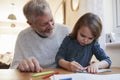 Grandfather And Granddaughter Colouring Picture Together Royalty Free Stock Photo