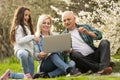 grandfather granddaughter and daughter with laptop in the garden