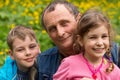 Grandfather, granddaughter and grandson smiling