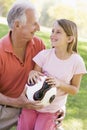 Grandfather and granddaughter outdoors with ball