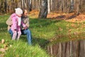 Grandfather with granddaughter in wood in autumn