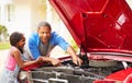 Grandfather And Granddaughter Working On Restored Car