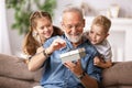 Grandfather and grandkids opening present Royalty Free Stock Photo