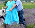 Grandfather and grandmother in a lavender field on a bicycle ride and relax together. Older Lifestyle