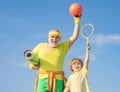 Grandfather and grandson with basketball ball and yoga mat in hands. Father and son having workout. Age is no excuse to Royalty Free Stock Photo