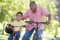 Grandfather and grandson on bikes outdoors smiling Royalty Free Stock Photo