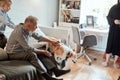 Grandfather and grandson with dog sitting at couch in room Royalty Free Stock Photo