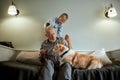 Grandfather and grandson with dog sitting at couch in room Royalty Free Stock Photo