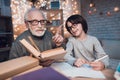 Grandfather and grandson are doing homework at night at home. Granddad is helping boy. Royalty Free Stock Photo