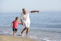 Grandfather And Grandson Enjoying Walk Along Beach Royalty Free Stock Photo