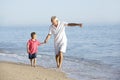 Grandfather And Grandson Enjoying Walk Along Beach Royalty Free Stock Photo