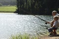 Grandfather And Grandson Fishing By Lake Royalty Free Stock Photo