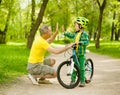 Grandfather and grandson give high five while cycling in the park Royalty Free Stock Photo