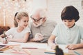 Grandfather, grandson and granddaughter at home. Royalty Free Stock Photo