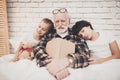 Grandfather, grandson and granddaughter at home. Grandpa and children are sleeping while reading book. Royalty Free Stock Photo