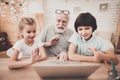 Grandfather and grandchildren waving to laptop. Royalty Free Stock Photo