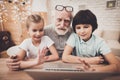 Grandfather hugs his grandson and looks at laptop. Royalty Free Stock Photo