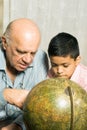 Grandfather and Grandson Look at a Globe