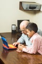 Dědeček vnuk kouká na hračka počítač 