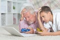 Grandfather and grandson lying on floor and playing computer games on laptop Royalty Free Stock Photo