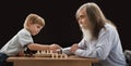 Grandfather and Grandson Playing Chess Game. Senior Elder Man teaching Little Child Logic Board Game. Little Boy Checkmate Teacher Royalty Free Stock Photo