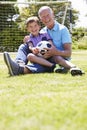 Grandfather And Grandson Playing Football In Garden Royalty Free Stock Photo