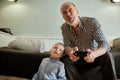 Grandfather and grandson playing video games on computer with joystick Royalty Free Stock Photo