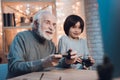 Grandfather and grandson are playing video games on computer at night at home. Royalty Free Stock Photo