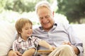 Grandfather With Grandson Reading Together On Sofa Royalty Free Stock Photo