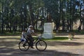 Grandfather and grandson ride a bike in the park.