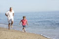 Grandfather And Grandson Running Along Beach Royalty Free Stock Photo