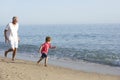 Grandfather And Grandson Running Along Beach Royalty Free Stock Photo