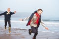 Grandfather And Grandson Running On Winter Beach Royalty Free Stock Photo