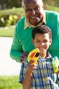 Grandfather And Grandson Shooting Water Pistols