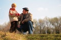 Grandfather and the grandson sit on hillock Royalty Free Stock Photo
