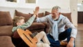 Grandfather with grandson sitting and giving high five each other after teaching playing guitar Royalty Free Stock Photo