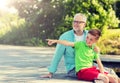 Grandfather and grandson sitting on river berth Royalty Free Stock Photo