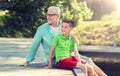 Grandfather and grandson sitting on river berth Royalty Free Stock Photo