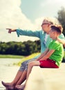 Grandfather and grandson sitting on river berth Royalty Free Stock Photo