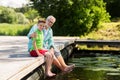 Grandfather and grandson sitting on river berth Royalty Free Stock Photo