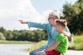 Grandfather and grandson sitting on river berth Royalty Free Stock Photo