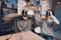 Grandfather and grandson are using virtual reality at night at home.