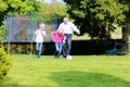 Grandfather and grandsons playing soccer in the garden