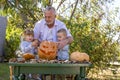 Grandfather helping children to carve a pumpkin for Halloween Royalty Free Stock Photo