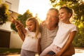 Grandfather with his granddaughters on street looking something fanny.