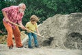 Grandfather with his grandson hard working. Little grandson helping his grandfather with building work. Child and works