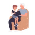 Grandfather with his grandson reading book in cozy armchair