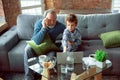 Grandfather and his grandson spending time insulated at home, stadying, watching cinema, shopping together