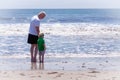 Grandfather with his grandson walking on a beach Royalty Free Stock Photo